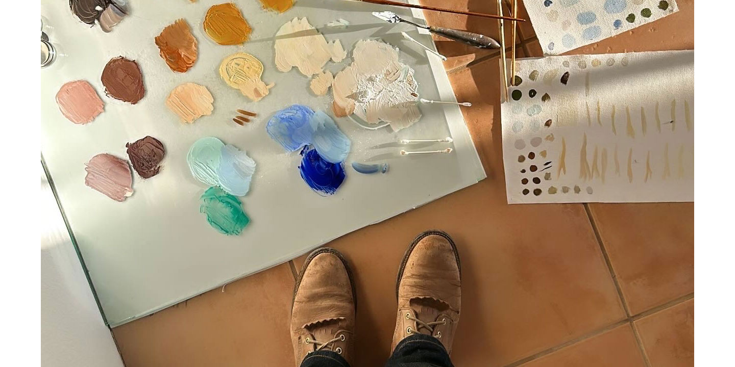 A photo of an artist’s brown boots with the artist standing over